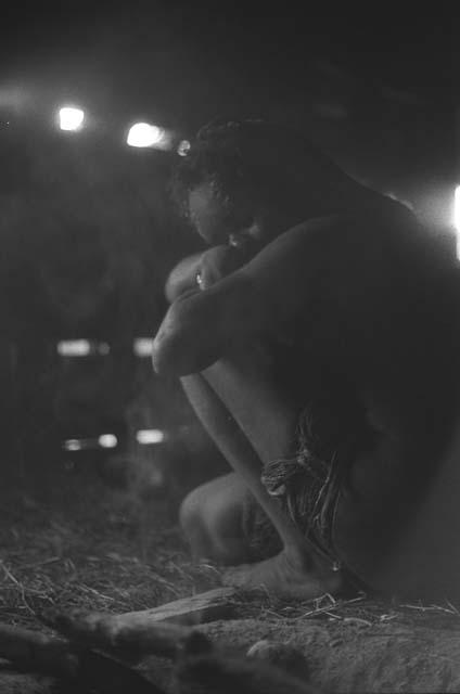 Samuel Putnam negatives, New Guinea; a woman rests on her knees; inside a hunu