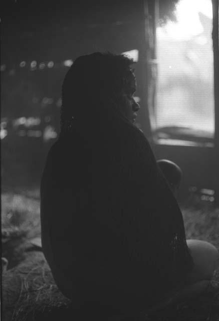 Samuel Putnam negatives, New Guinea; woman seated in a hunu; light coming thru the door in fron of her