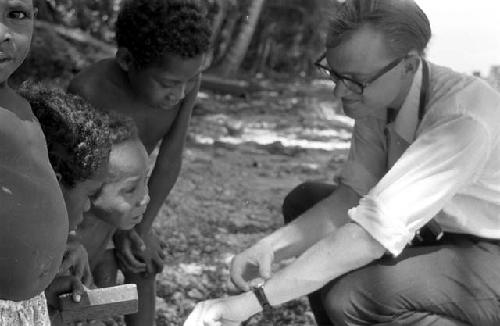 Karl Heider negatives, New Guinea; Biak, Children; Michael Rockefeller showing his watch to children