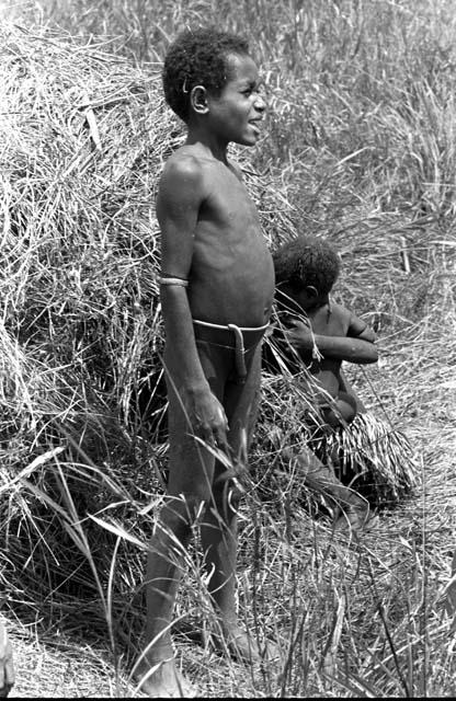 Karl Heider negatives, New Guinea; Uwar standing beside toy hanoi