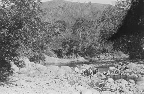 Women catching fish under stones