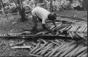 Weaving palm leaves to make saddle board for roof