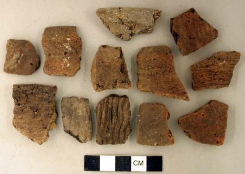 Coarse earthenware body and rim sherds, some undecorated, some cord impressed, some punctate, some rocker dentate, some incised