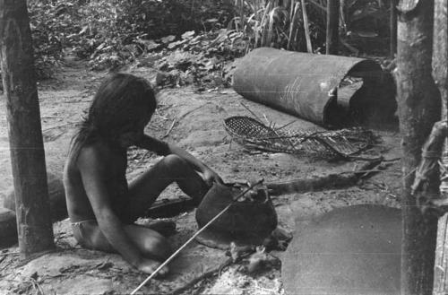 Corner of a house; note cassava pan, lower right corner; upturned trough for cassava mash; delapidated walisha in middle rear