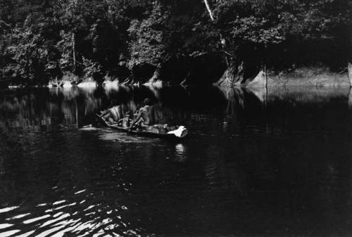 Carib man in woodskin canoe