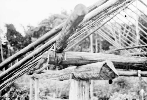 Closeup of house frame-work showing method of tying wall plate to transverse beam and flanged top of upright for receiving stringer.