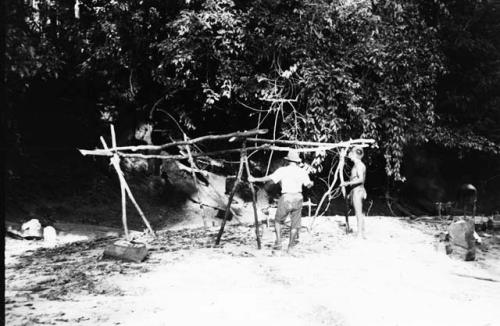 Views showing method of constructing a temporary shelter frame.