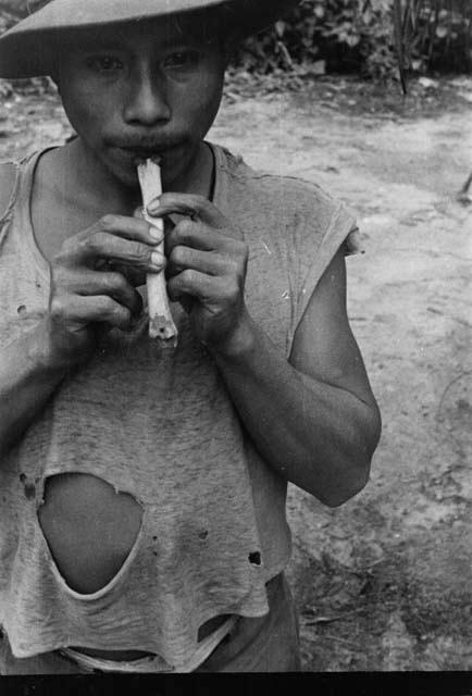 Man playing flageolet made from tibia of deer