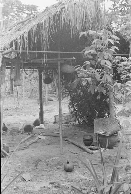 Typical interior of small house -- note calabash water vessel in foreground, pots, walishas to right, etc(?)