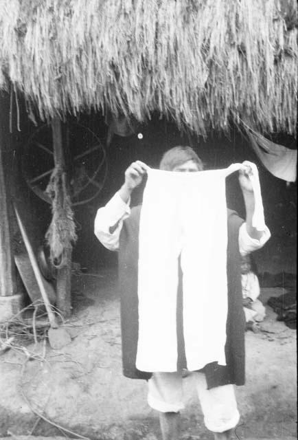 Man holding men's pantaloons in hand, made of homespun cloth