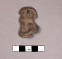 Small crude slightly water rolled pottery sitting figurine.