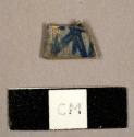 Burned whiteware sherd with blue hand painted design, rim sherd to a possible saucer