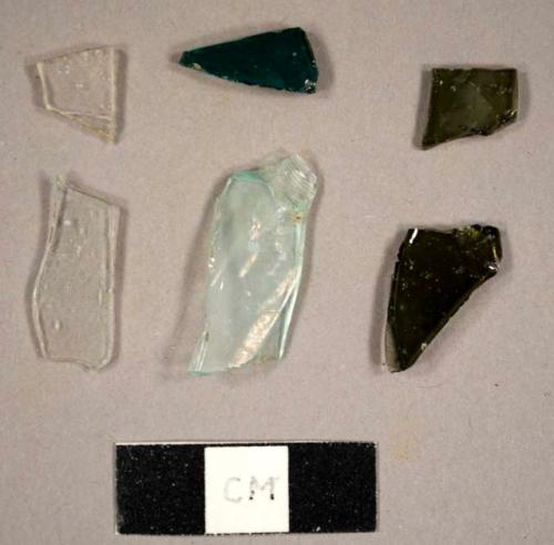 Assorted curved glass fragments, including colorless, aqua, olive green, and green fragments