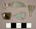 Curved glass fragments, including colorless, aqua, and olive green fragments