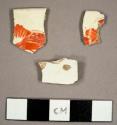 Whiteware sherds with handpainted red overglaze, including one saucer rim sherd