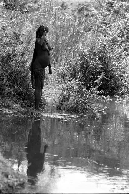 Woman drinking from gourd at Aikhe River