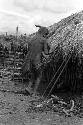 Dumakonem. woman with dismounted baby prepares to enter cook house.