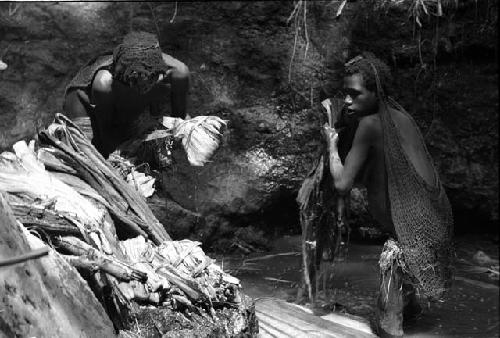 Ilueaima ('Kurelu Salt Well'). women take banana trunk from pool.