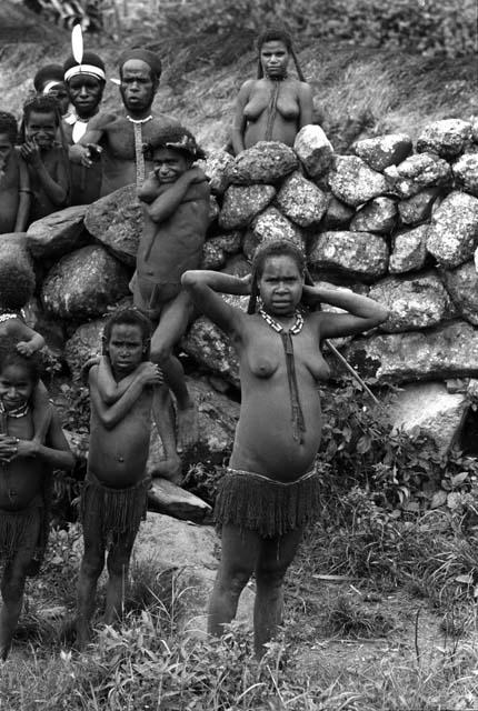 people at stone wall. (Moving South from Wamena, these stone walls gradually replace the wood fences of the Mid Grand Valley)