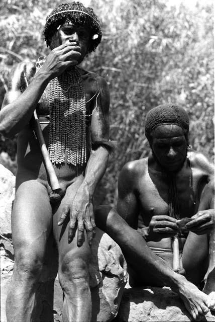 Two men sit smoking.