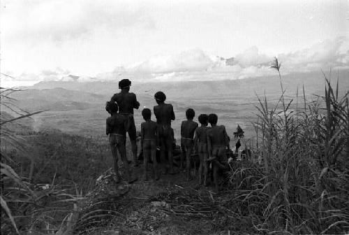 Kids on promontory above mountain wall, looking across GV