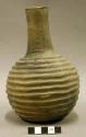 Ceramic complete vessel, slim neck, grooved around body, has a base