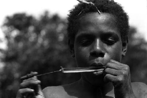 Isele plays bamboo mouth harp.