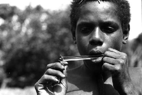 Isele plays bamboo mouth harp.