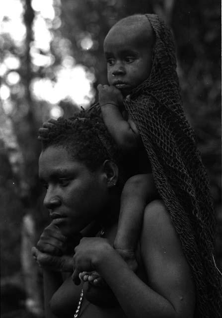 Woman carries Wamasue on shoulders.