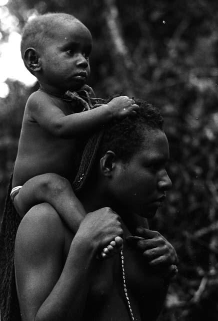 Woman carries Wamasue on shoulders.