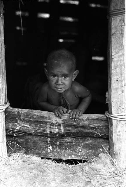 Wamasue looks out from hunu doorway.