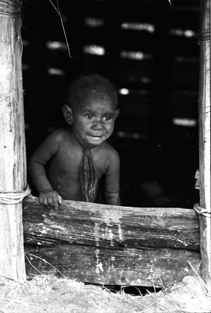 Wamasue looks out from hunu doorway.