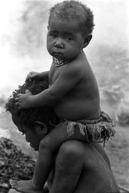 child on girl's shoulders