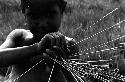 Karl Heider negatives, New Guinea; Milika's son making grass stem toys