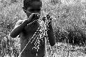 Karl Heider negatives, New Guinea; Milika's son making grass stem toys