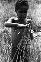 Karl Heider negatives, New Guinea; Milika's son making grass stem toys