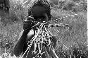 Karl Heider negatives, New Guinea; Milika's son making grass stem toys