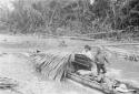 Showing method of building palm leaf shelter on canoe, used by travellers