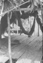 Interior of temporary house with raised floor of split bamboo and the hammock