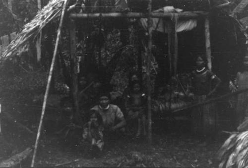 Men, women and children in typical costume and typical temporary hut