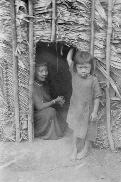 Woman and child showing size of house door