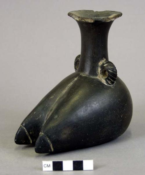 Black pottery jar in form of a llama foot