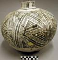 ceramic jar, black on white exterior, mended