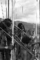 Men and young boy warriors watching the war; Yoli in the middle