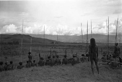 Wide angle; men on the Warabara; watching the war way in the distance; Polik stands behind some of the other men