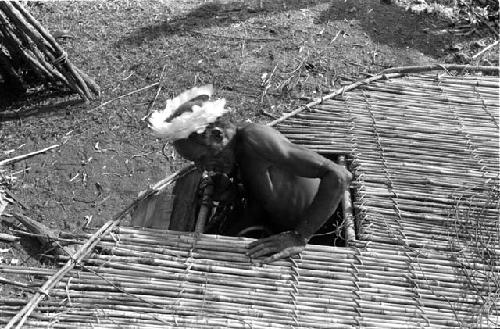 Man coming through hole in henapu floor