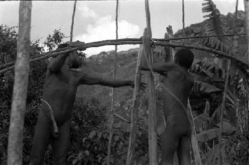 Two men building a roof