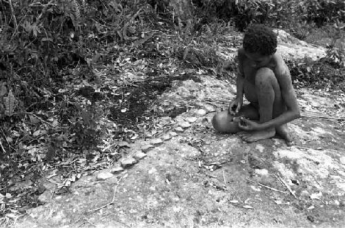 Kousa playing with perhaps an insect; spotted on a huge rock