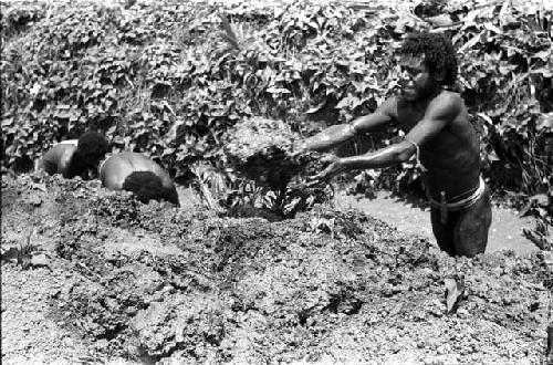 Woluklek and another man clearing a ditch