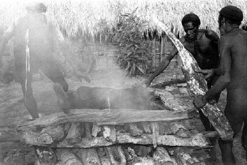 Corpse covered in logs on the fire